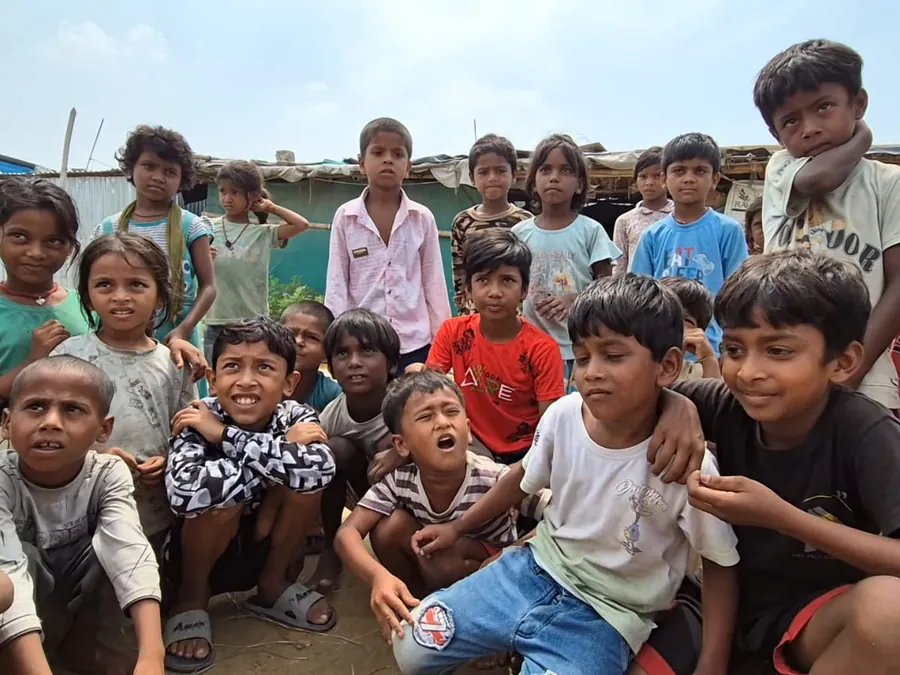 Children gathered outside the corrugated-metal shelters where they live.