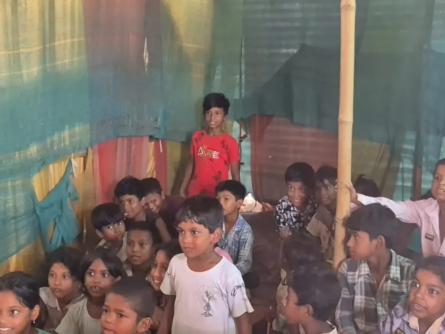 Children sitting together beneath coloured netting during a session.