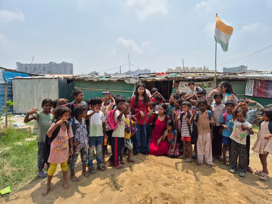 The Aadyah team and children outside the learning centre, beneath the Indian flag.