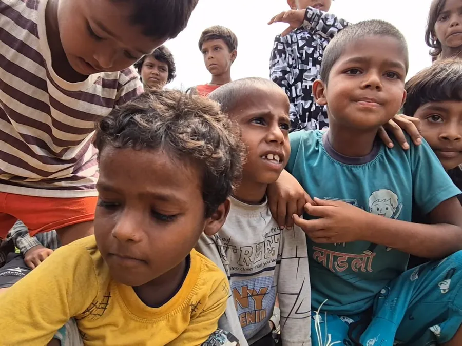 A close group of children leaning on one another, mid-conversation.